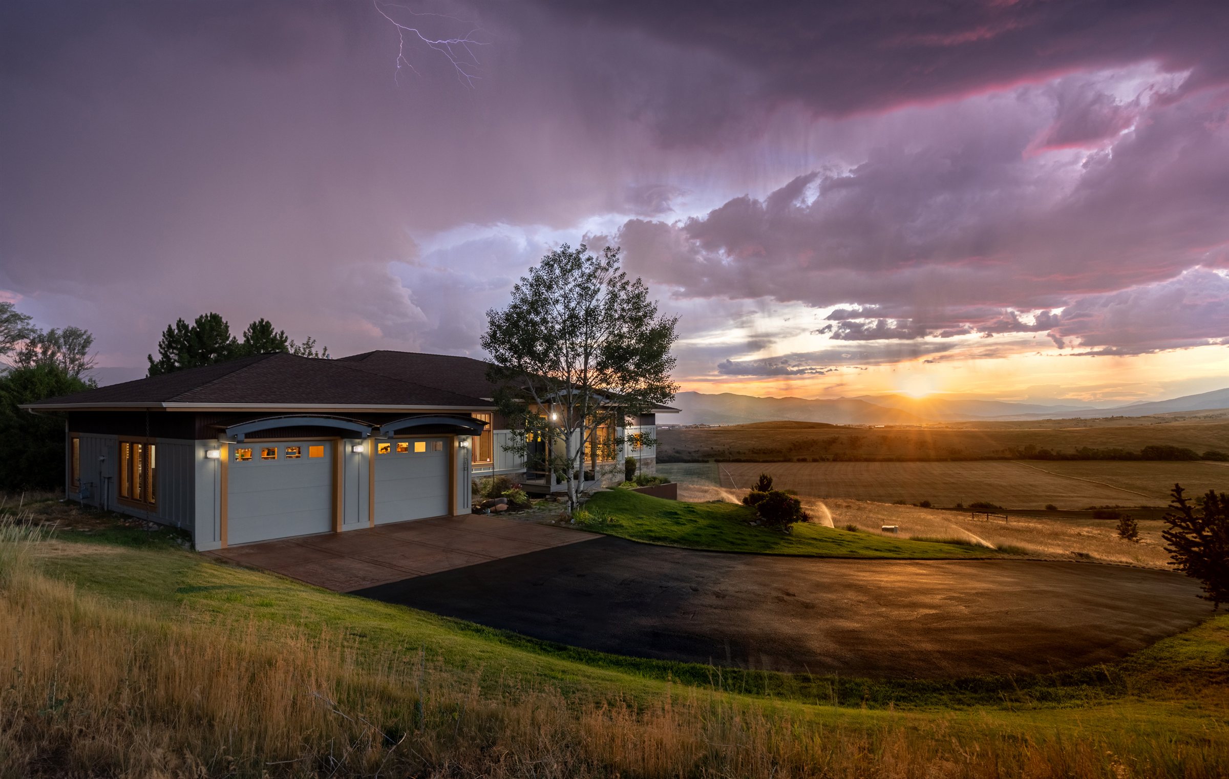 Missoula home at twilight beneath a lightning storm and mountain sunset, photographed by PMZ Photography